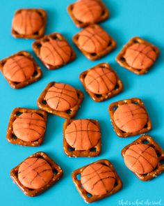 some pretzels that are shaped like basketballs on a blue surface with caramel glaze