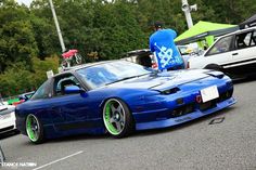 a blue sports car parked next to other cars