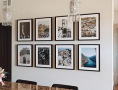 a dining room table with chairs and pictures on the wall above it, along with chandelier