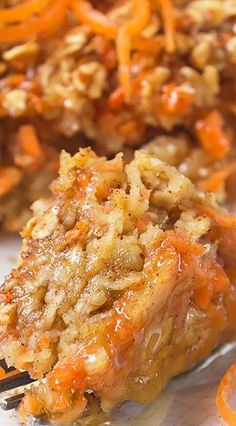 a close up of food on a fork with carrots and bread crumbs