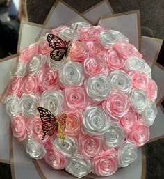 a bouquet of pink and white roses with butterflies on them