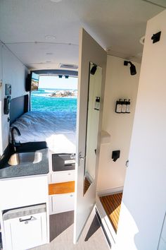 an open door leading to a kitchen area with sink and stove top in the foreground