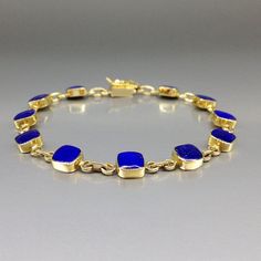 Timeless bracelet blue Lapis Lazuli and solid 18K gold. Unique gift for her, girlfriend, wife, September and December birthstone, 9 year anniversary. The bracelet combines simplicity and elegance in design and trough the combination of the blue Lapis Lazuli with the warm 18K gold. This beautiful Bracelet is worked with the technique of inlay, which means the stone is worked seamlessly into the 18K gold with a full back gold. All our stones are natural stones and our jewelry is handmade, slight differences in color and size may occur. Our inlay work is made with real stone and NOT stone dust. Please note the size specifications! Stone size: 6 x 6 x 2mm weight: 11.7 g - 12.9 g     Carat: 7 Gold: 10.3 g - 11.5 g                               We try to make our photos in daylight and sunshine, Classic Gold Bracelet With Bezel Setting As Gift, Timeless Gold Bracelet With Bezel Setting As Gift, Formal 14k Gold Bracelets With Bezel Setting, Blue Jewelry With Jubilee Bracelet For Anniversary, Timeless Blue Bracelet For Formal Occasions, Fine Jewelry Blue Gold Bracelet For Gift, Blue Bracelets With Polished Finish For Formal Occasions, 14k Gold Bracelet With Birthstone For Formal Occasions, Formal 14k Gold Bracelet With Birthstone