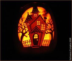 a carved pumpkin with a house on it