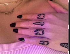 two hands with black nail polish and tattoos on them