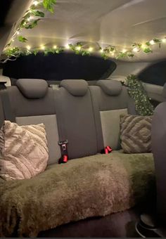 the interior of a car with several pillows and lights