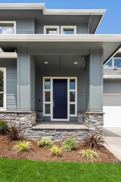 a gray house with white trim and blue front door is shown in the suburbs of vancouver, canada