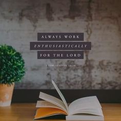 an open book sitting on top of a wooden table next to a potted plant