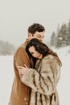 a man and woman hugging in the snow