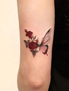 a woman's arm with a butterfly and roses tattoo on it