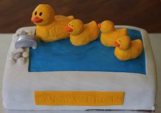 a cake decorated with rubber ducks in a pool