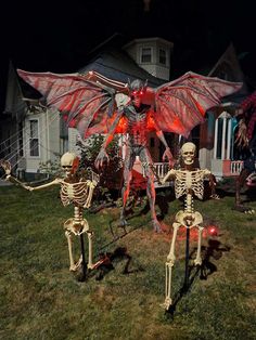 two skeleton skeletons in front of a house decorated for halloween with red lights and decorations