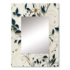 a mirror that is sitting on top of a white surface with leaves and flowers around it