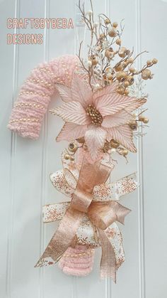 a pink and gold wreath on the front door with words craftybea designs