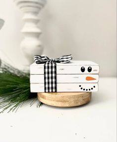 a snowman is wrapped in black and white paper with a bow on it's head