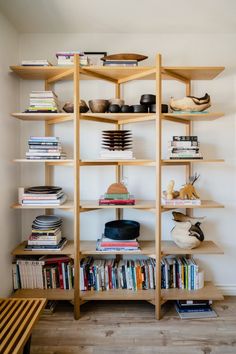 a bookshelf filled with lots of books on top of wooden shelves next to a wall