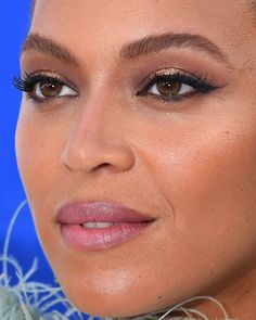 a close up photo of a woman with long hair and eyeliners on her face