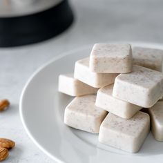 a white plate topped with marshmallows on top of a marble countertop