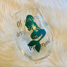 a wine glass with the words mermaid on it and a silhouette of a woman holding a fish