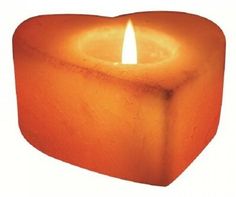 an orange candle is lit in the shape of a heart