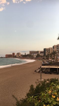 an empty beach with buildings in the background