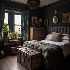 a bedroom with a bed, suitcases and pictures on the wall next to it