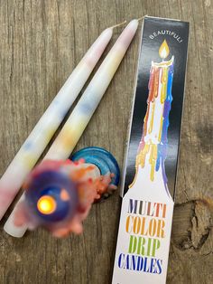 multicolored candles sitting on top of a wooden table next to a candle holder