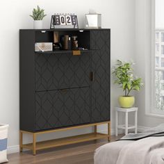 a bedroom with a bed and a black cabinet next to a white wall in front of a window