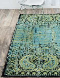 a blue rug with an ornate design on the bottom and green, black, and yellow colors