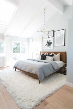 a bed room with a neatly made bed and pictures on the wall