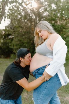 a pregnant woman is being hugged by a man