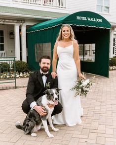 a bride and groom pose with their dog in front of the hotel walloon on their wedding day