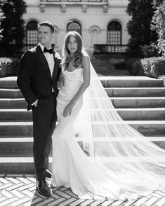 a bride and groom standing in front of some steps