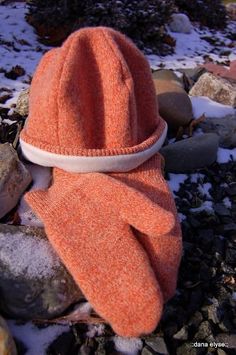 an orange hat is laying on some rocks