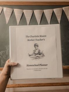 the charlotte mason mother - teacher's homeschool planner is held up in front of a chalkboard