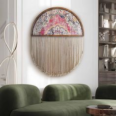 a living room with green couches and a round mirror on the wall above it