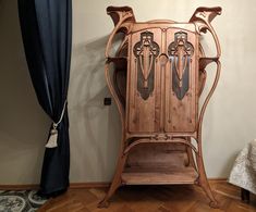 an old wooden cabinet with ornate carvings on the front and sides, against a wall