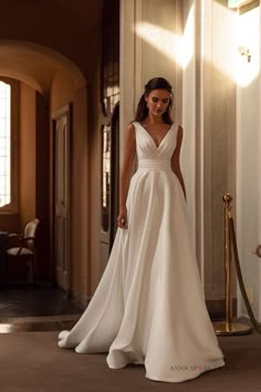 a woman in a white wedding dress standing on the floor