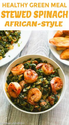 a white bowl filled with spinach and shrimp next to some fries on the side