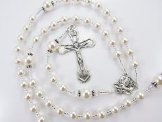 "- Personalized handmade Swarovski crystal pearl rosary in white. - Choice of medals and letters - Comes with velour pouch and gift box This Catholic rosary is made with all Swarovski pearls and Swarovski crystal accent beads and comes personalized with one name and your choice of Baptism, First Communion, Confirmation, or other various medals - read below for details. Over 80 colorful designs to choose from. Enter my shop here: https://www.etsy.com/shop/rosarygardencathy Personalization: ~ SQUA Catholic Baptism, Personalized Rosary, Rosary Gift, Pearl Rosary, First Communion Gifts, Girl Christening, Catholic Rosary, Communion Gifts, Baptism Girl