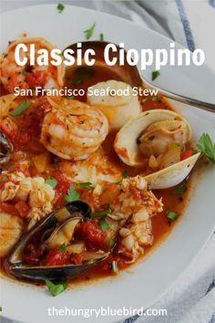 a white plate topped with seafood and clams in tomato sauce, garnished with parsley