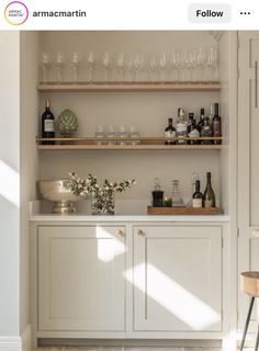 a kitchen filled with lots of bottles and glasses on top of it's shelves