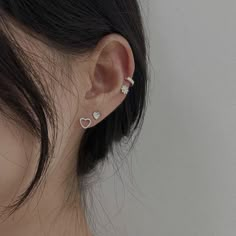 a close up of a person's ear with two small hearts on the side