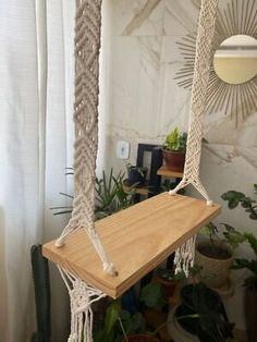 a hammock hanging from the ceiling in a room with plants and potted plants