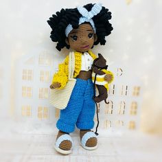 a crocheted doll holding a stuffed animal in it's arms and wearing blue pants