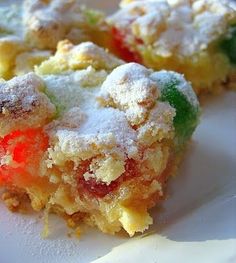 a close up of a piece of cake on a plate with powdered sugar and jelly