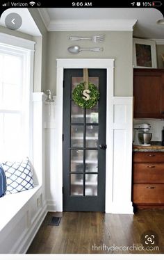 a kitchen with wood floors and white walls, has a glass door that leads to the breakfast nook