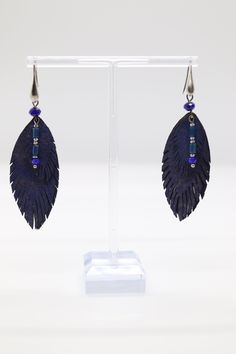 Blue feather earrings are delicate accessories crafted with vibrant blue feathers, elegantly dangling from a gold hook, adding a touch of nature-inspired beauty to any outfit. Their graceful design complements both casual and formal styles, making them a versatile and eye-catching addition to any jewelry collection. Elegant Blue Feather Earrings, Blue Feather Earrings As Gift, Blue Feather Earrings Gift, Blue Feather Earrings For Gift, Adjustable Blue Feather Earrings, Blue Feather Dangle Earrings, Blue Feathers, Beaded Earrings Patterns, Blue Feather