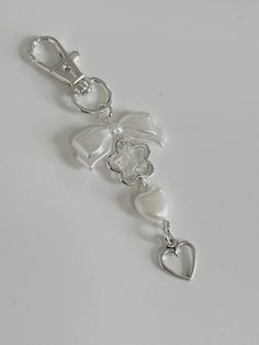 a keychain with a heart shaped charm attached to it on a white surface