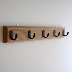 three coat hooks are mounted on a wall